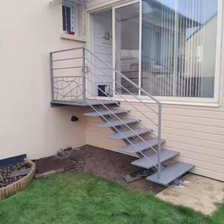 Escalier extérieur 6 marches + 1 palier. Marches en acier larmés. Garde corps en aluminium, cadre 40x20mm, remplissage en lisses D.16 + soubassement habillage décoratif "spline" sur le garde corps droit. 53810 CHANGE