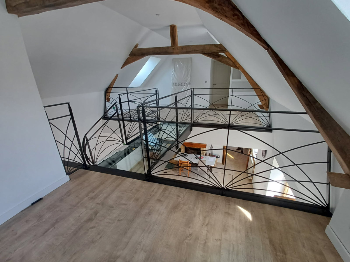 Escalier limon central 1/4 tournant débillardé, marches en chêne rustique sablé, laquage ral 2100 sablé Garde corps poteaux plats, remplissage lisses D.10 cintrées, main courante 40x10, laquage ral 2100 sablé Ossature en UPN, remplissage en dalle de verre clair, laquage de l'ossature ral noir 2100 sablé 72170 SEGRIE