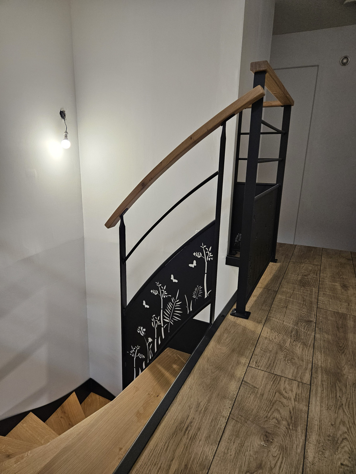 Escalier double limons en acier Marches et main courante en bois Garde corps en acier, lisses D.13, soubassement en habillage décoratif "fleurs- papillons". 53440 GRAZAY