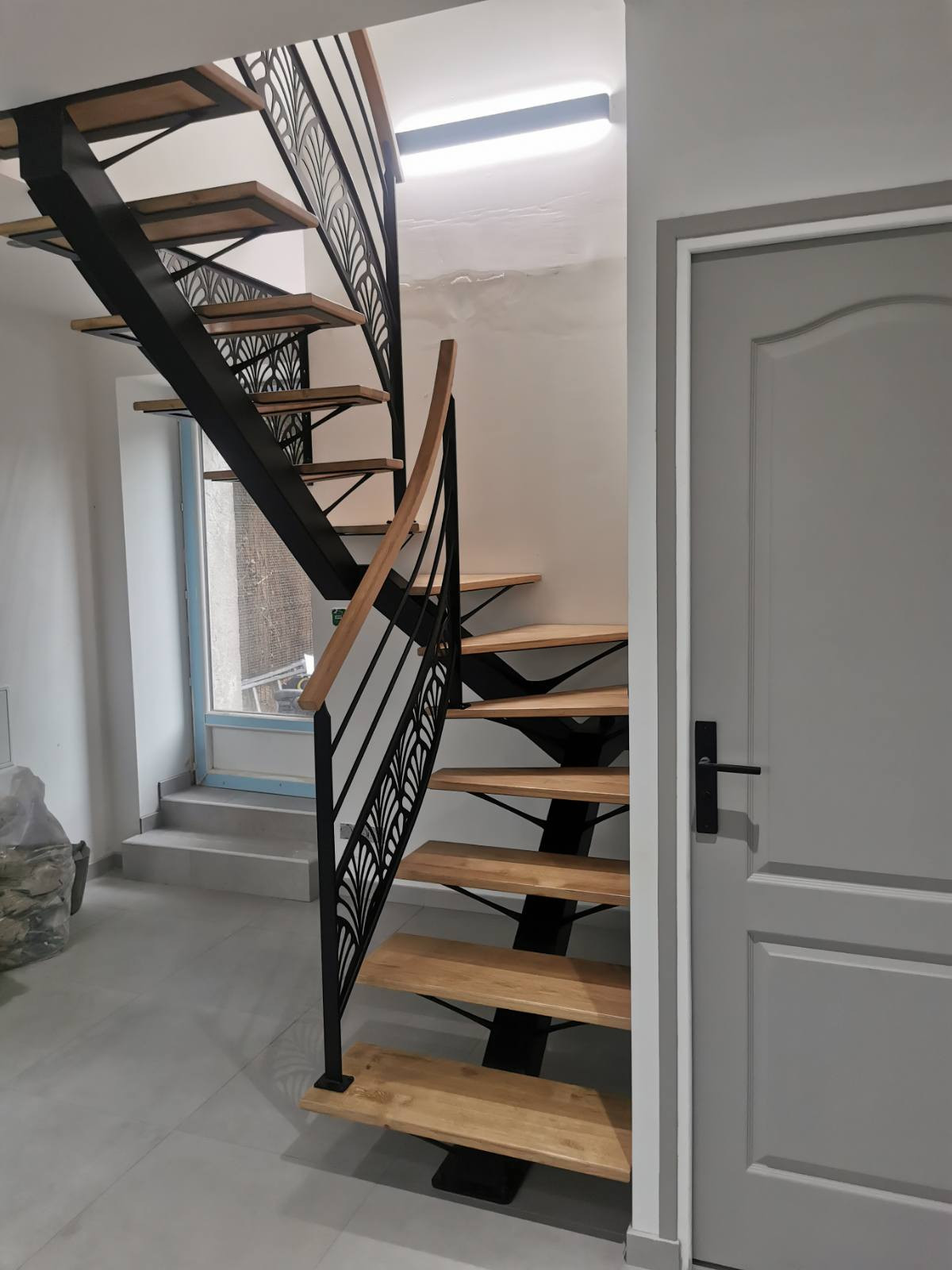 Escalier 2/4 tournant, limon central en acier Marches et main courante en chêne garde corps avec 2 lisses+ habillage décoratif "oriental" Laquage ral noir 9005 FT 72140 ROUESSE-VASSE