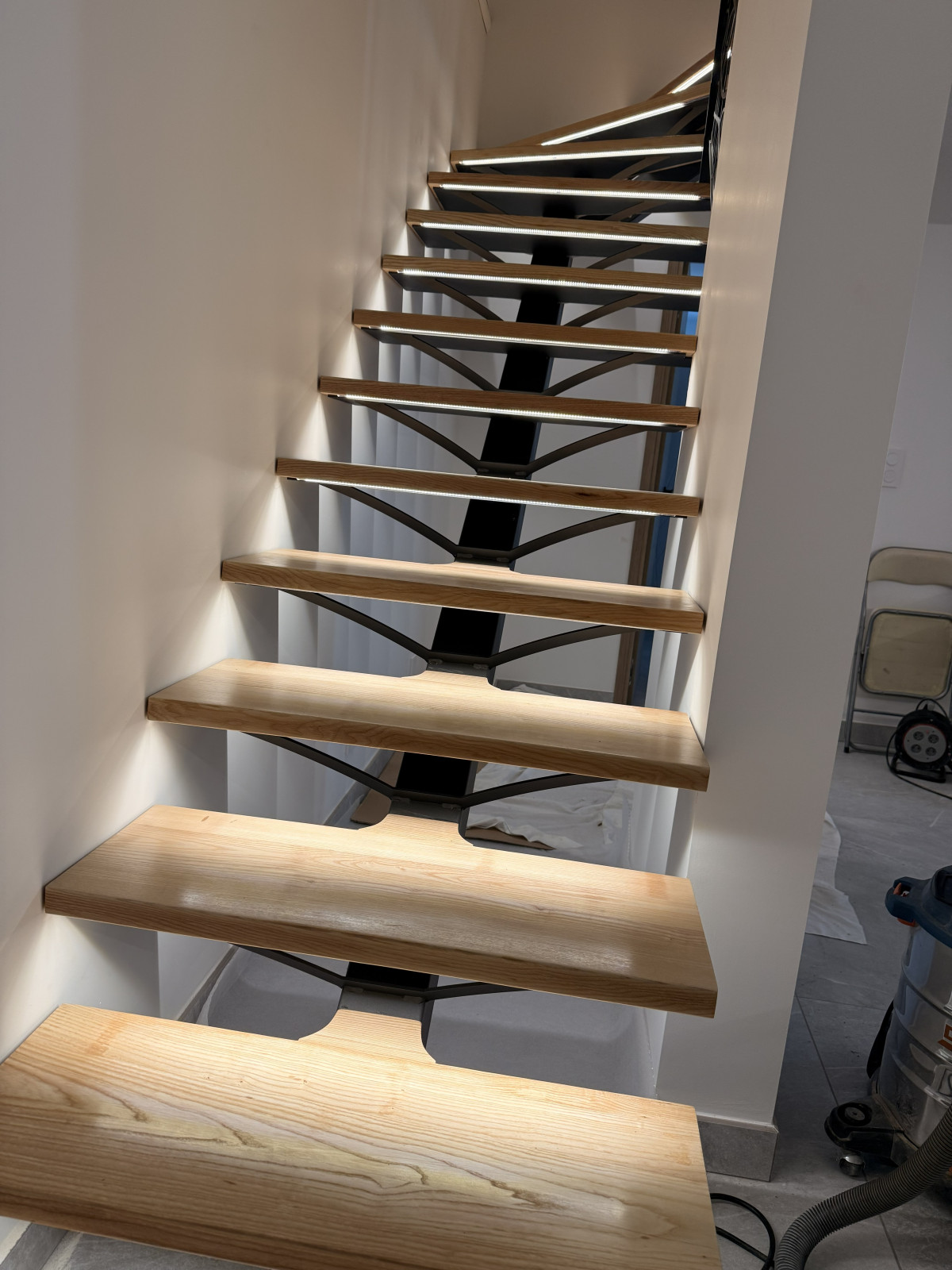 *Escalier limon central 1/4 tournant en acier Ruban Led dans profil d'encastrement avec capotage pvc opaque Garde corps en acier, ligne de câble, soubassement en habillage décoratif "spline" Laquage ral noir 2100 sablé *Ossature vide sur sejour en tube, laquage ral noir 2100 sablé Remplissage en filet d'habitation maille 30x30 tressé couleur beige 53100 Moulay