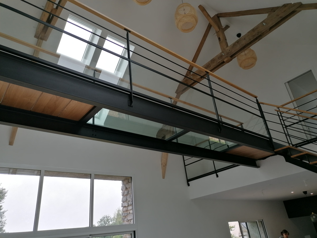 Passerelle, remplissage en chêne vitrifiées style parquet et dalle de verre clair, garde corps en acier, poteaux plats, 2 lisses D.13, soubassement vitrage+pareclose, main courante 50x30 en chêne, laquage ral 9005 Fine Texture, 53210 LOUVIGNE.