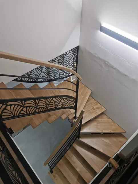 Escalier 2/4 tournant, limon central en acier Marches et main courante en chêne garde corps avec 2 lisses+ habillage décoratif "oriental" Laquage ral noir 9005 FT 72140 ROUESSE-VASSE