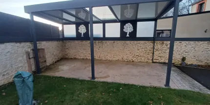 Pergola Toiture en panneau compressé Isotoit Panneau vitré et habillage décoratif "arbre" Laquage ral 7016 FT 53600 Evron