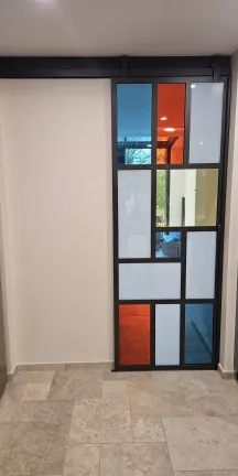 Fabrication d'une porte verrière coulissante châssis en acier Remplissage en vitrages de différentes couleurs Laquage compris noir 2100 sablé 53600 EVRON