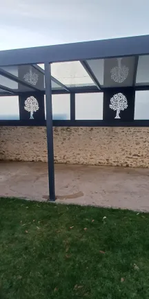 Pergola Toiture en panneau compressé Isotoit Panneau vitré et habillage décoratif "arbre" Laquage ral 7016 FT 53600 Evron