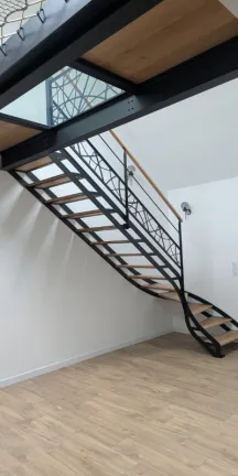 Escalier double limons ajourés 1/4 tournant Passerelle avec 2 dalles de chêne, 1 dalle de verre Garde corps, poteaux plats, 2 lisses, soubassement en habillage décoratif "courbes" Marches et main courante en chêne vernis 2 couches polyuréthane Laquage ral 9005 FT 72130 SOUGE LE GANELON