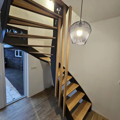 Escalier double limons en acier Marches et main courante en bois Garde corps en acier, lisses D.13, soubassement en habillage décoratif "fleurs- papillons". 53440 GRAZAY