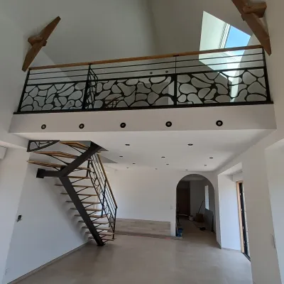Fabrication d'un escalier limon central 1/4 tournant en acier Marches et main courantes en chêne Garde corps en acier, poteaux plats, 2 lisses D.13, soubassement en habillage décoratif. Laquage ral noir 2100 sablé 53300 ST FRAIMBAULT DE PRIERES