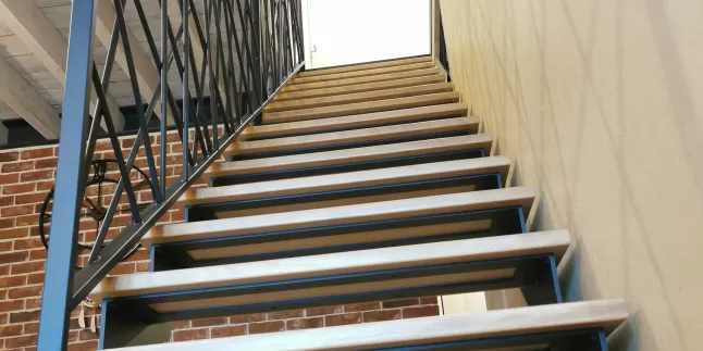 Escalier droit en acier, double limons crémaillère, marches en chêne vitrifiée 2 couches, garde corps en acier, ossature en cadre 40x20mm, remplissage en lisses D.13 entremêlées, laquage ral noir 9005 FT.