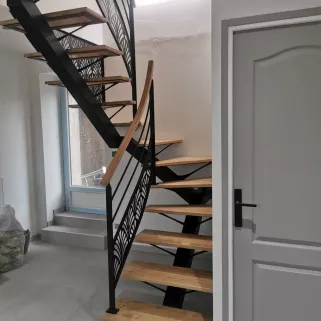 Escalier 2/4 tournant, limon central en acier Marches et main courante en chêne garde corps avec 2 lisses+ habillage décoratif "oriental" Laquage ral noir 9005 FT 72140 ROUESSE-VASSE