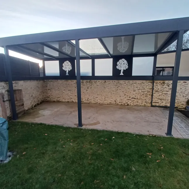 Pergola Toiture en panneau compressé Isotoit Panneau vitré et habillage décoratif "arbre" Laquage ral 7016 FT 53600 Evron